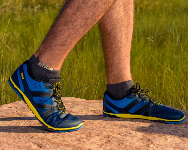 A close up shot of a man standing on a rock in his HFS II running shoes.